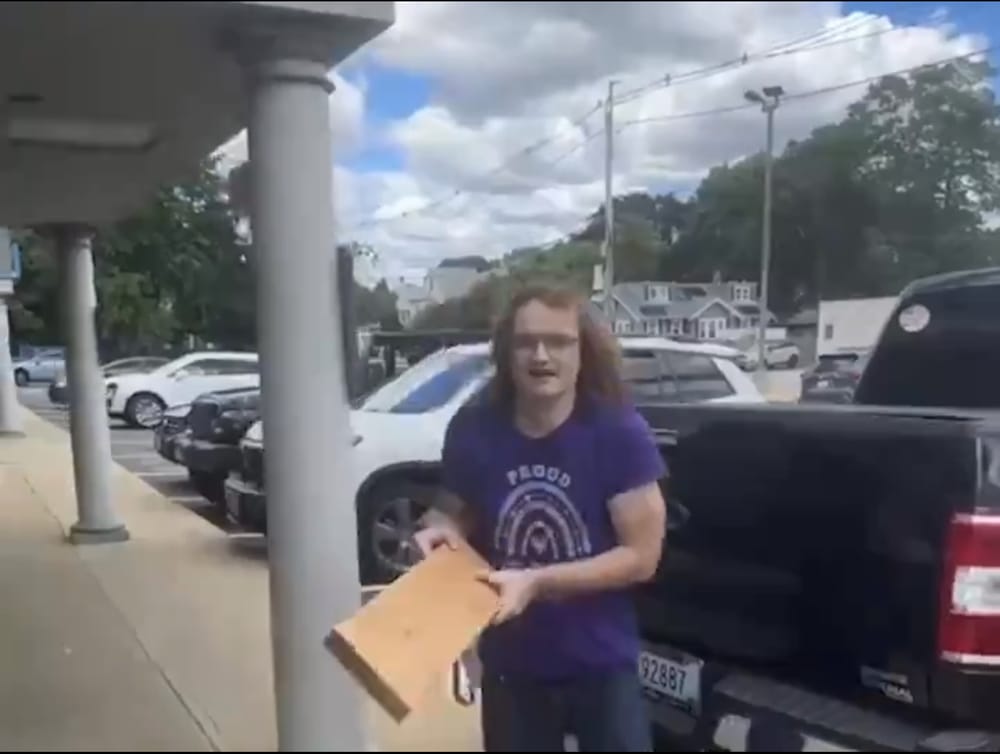 WATCH: A trans man wearing a "Proud Trans Teacher" t-shirt, carrying a wooden plank, caused a disturbance at a store owned by a Trump supporter in Rhode Island post image